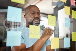 An hour of planning can save you 10 hours of doing. a businesswoman brainstorming with sticky notes on a glass screen.