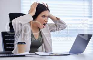 Just when you thought it was safe to log off. a young businesswoman looking angry while using a laptop in a modern office.