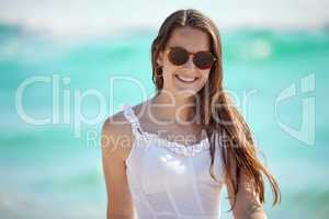 Catch me at the seashore. a young woman enjoying a day at the beach.