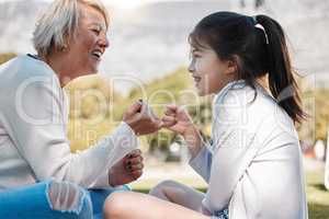 My love for you is no secret. a little girl and her grandmother making a pinky promise outdoors.