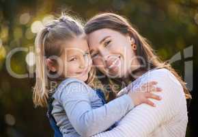 I will always hold her near and dear. Portrait of a mother and her little daughter bonding together outdoors.