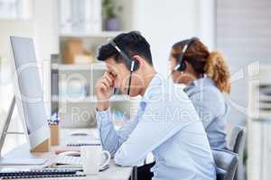 Annoyed, frustrated and stressed call center agent with a headache and working in customer service. Male IT support assistant struggling with a migraine, feeling angry, upset and irritated