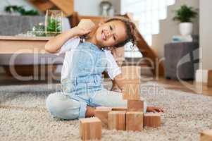 Playtime is the best time. Portrait of an adorable little girl playing with wooden blocks at home.