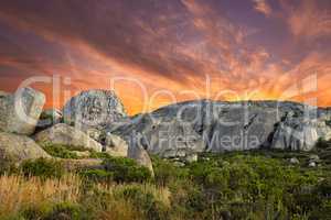 Beautiful, bright and ambient sky at sunset with big boulders outdoors on a nature landscape. Dramatic scene of the wilderness at dawn in a natural, secluded and untouched wilderness environment