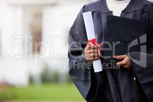 An investment in knowledge pays the best interest. Closeup shot of an unrecognisable woman holding a certificate and cap on graduation day.