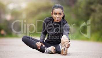 My journey will be amazing. a sporty young woman stretching her legs while exercising outdoors.