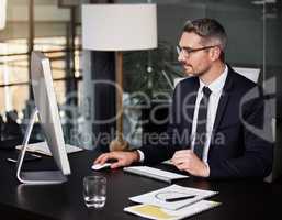 Delivering excellent work is what opens new doors. a businessman using his computer while sitting at his desk.
