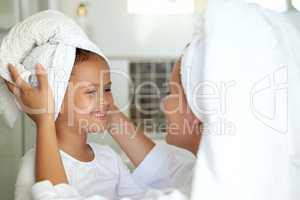 Hygiene, washing hair and grooming with haircare routine for a mother and daughter home spa day. Happy, caring and sweet child and parent bonding over healthy skincare or relaxing pampering treatment