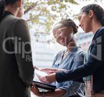 Sharing new ideas. a group of businesswomen going through paperwork against a city background.