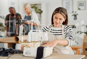 Fashion, design and creative work in a textile workshop. Young female factory worker stitching trendy and stylish clothing in a startup. Busy tailor working on a sewing machine in a small business