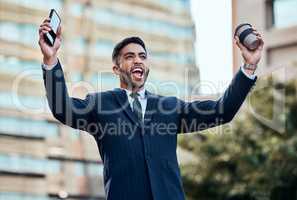 Guess whos employee of the month. a handsome young businessman standing alone outside and celebrating a success.