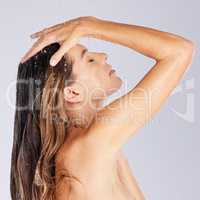 Feeling a sense of ultimate relaxation wash over her. Studio shot of an attractive young woman taking a shower against a grey background.