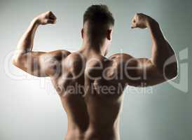 Intensity build immensity. Studio shot of a muscular young man posing against a grey background.