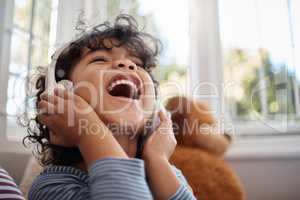 Dreading the day my world falls silent or into key. an adorable young boy using headphones in his bedroom at home.