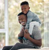 Me and my little man. Cropped portrait of a handsome young man sitting on the bed at home with his son on his shoulders.