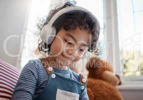I hope youll never find the rainbows end. an adorable young boy using headphones in his bedroom at home.