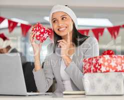 Lets play Guess that Christmas gift. a young businesswoman receiving a gift in a modern office at Christmas.
