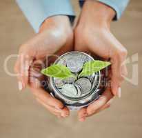 Top view of money, coins and cash in a jar for savings, budget and future needs. Closeup of the hands of a person holding a jug growing with funds for spending, payment or donation from above