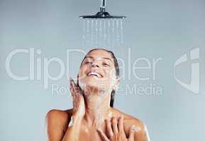 So fresh and so clean. a young woman taking a shower against a grey background.