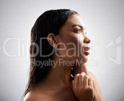 She is perfection. an attractive young woman looking thoughtful while posing in studio against a grey background.