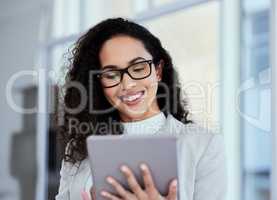Responding to emails all day. a young businesswoman using her digital tablet.