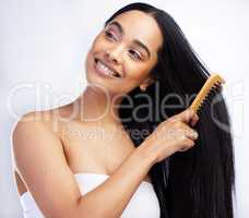 Ive got all the knots out. an attractive young woman standing alone in the studio and brushing her hair.