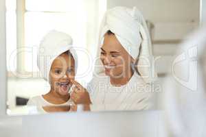 Smiling, joyful and excited little girl in spa with her mother. Mom and daughter self care day, putting on creams and taking care of skin. Parenthood, bonding with child, young female growing up