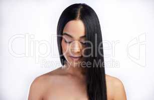 Sleek hair is my style. an attractive young woman standing alone in the studio.