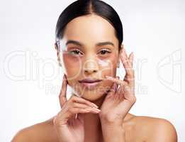 Targeting dark circles and fine lines for smoother skin. Studio portrait of a beautiful young woman wearing under-eye patches against a white background.