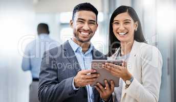 Follow us to learn more about what we do. two businesspeople standing together and holding a digital tablet in an office.