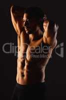 Move your body, grow your muscles. Studio shot of a fit young man posing against a black background.