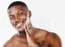 I damn-well am a great design. Studio portrait of a handsome young man applying moisturiser against a white background.