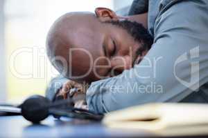 Burnout is real. a young businessman sleeping in an office at work.