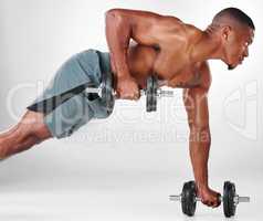 Keep looking to transcend. Studio shot of a shirtless handsome young man exercising with weights against a white background.
