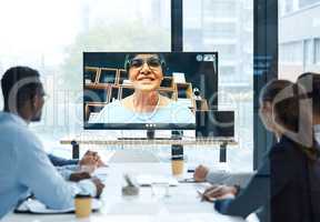Communication across the globe. a group of businesspeople having a video call with a colleague in an office.