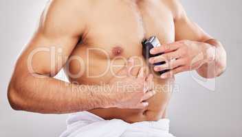 Beauty is pain. Cropped studio shot of an unrecognizable man shaving his chest against a grey background.