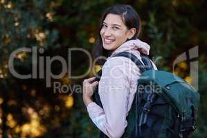 Lets go on an adventure. an attractive young woman standing alone outside and carrying a backpack.