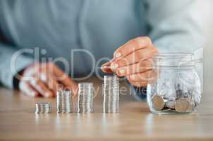 Savings, money and banking done by a business person on a table in an office at work alone. Closeup of the hands of a corporate professional stacking, piling and sorting coins to calculate budget