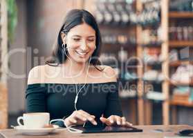 Beautiful, happy and relaxed student listening to a podcast, education video or music in cafe on a tablet. Smiling woman browsing online and watching distance learning webinar in restaurant