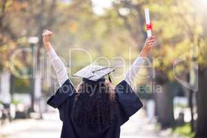 My first achievement but not the last. Rearview shot of a young woman cheering on graduation day.