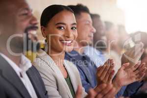 Im enjoying every minute of this. Cropped portrait of an attractive young businesswoman applauding while sitting with her colleagues in the boardroom during a presentation.