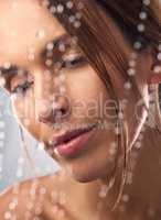 Experiencing total freshness. Studio shot of a beautiful young woman taking a shower against a grey background.