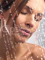 Clean skin leads to a happy me. Studio shot of a beautiful young woman taking a shower against a grey background.