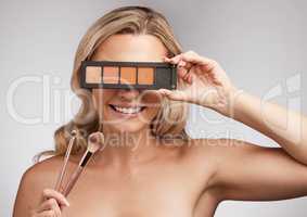 Beauty is the promise of happiness. Studio portrait of a beautiful young woman holding a set of makeup brushes against a grey background.