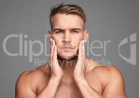 Rough skin Not on my watch. Studio shot of a handsome young man posing against a grey background.