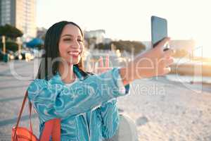 Fun, happy and trendy student taking a selfie on phone for social media while exploring, visiting and enjoying city. Stylish, edgy and funky woman taking photos on vacation while sightseeing town
