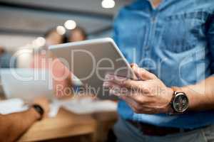 A paperless workspace is everyones responsibility. an unrecognisable businessman using a digital tablet during a conference in a modern office.