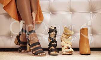 You have to have a bit of variety. a unrecognizable woman trying on heels in a clothing store.