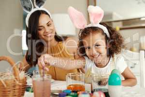 Mom says Im the best painter. a mother painting easter eggs with her daughter.