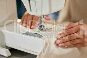 Sewing mends the soul. Closeup shot of an unrecognisable woman using a sewing machine in her workshop.